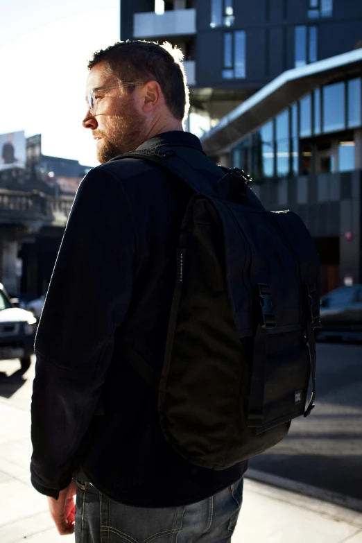 a man walking down a street while wearing a backpack