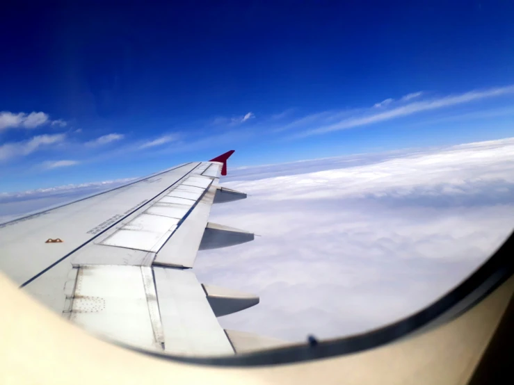 view of clouds through the window of an airplane