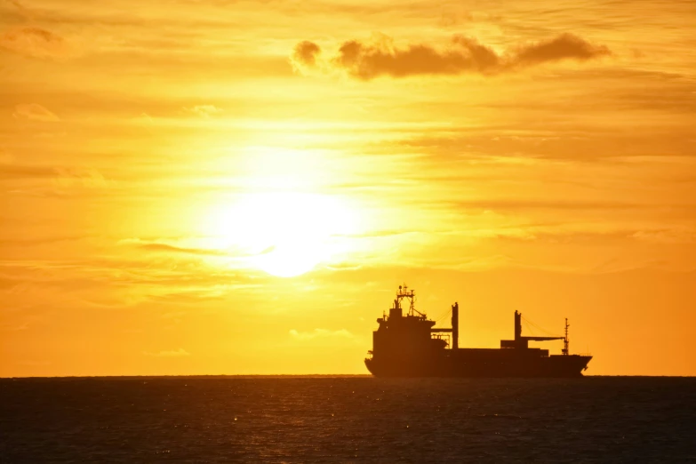 the ship is moving along the ocean at sunset