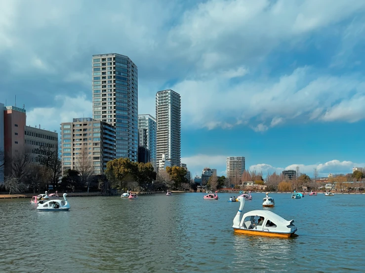 several small boats are in the water and some buildings