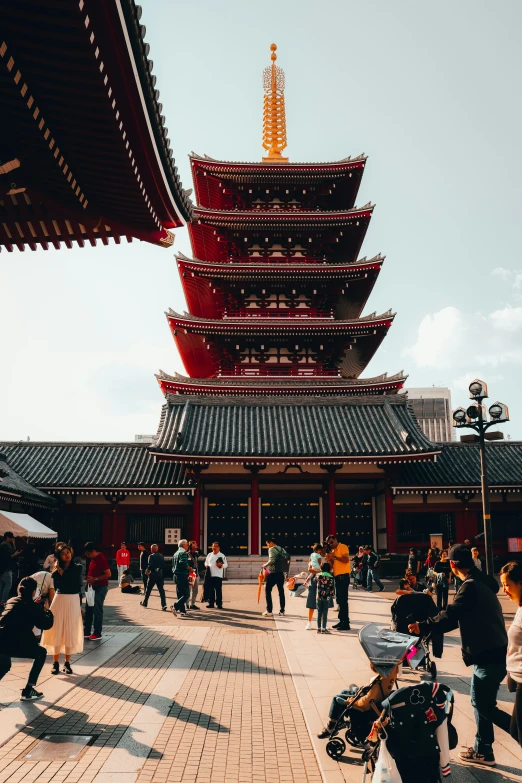 a group of people are walking around a pagoda