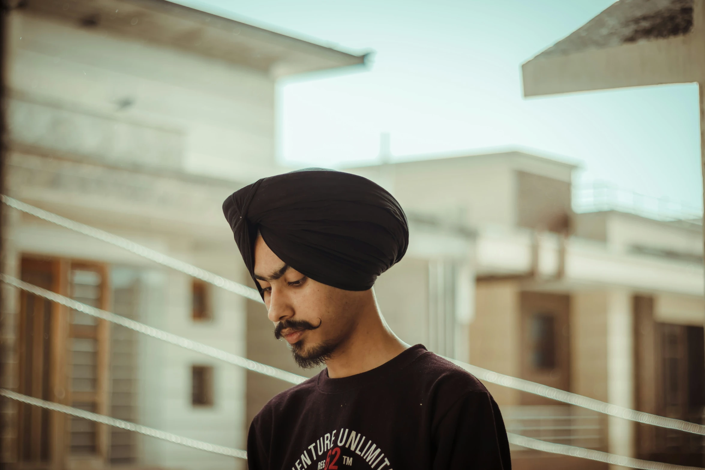 a man with a head wrap on looking at a cellphone