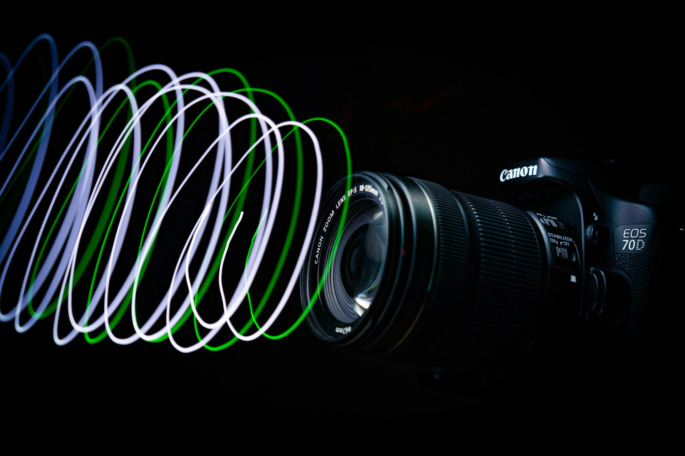 a camera with green and white lens sitting in front of some spiraly neon lights