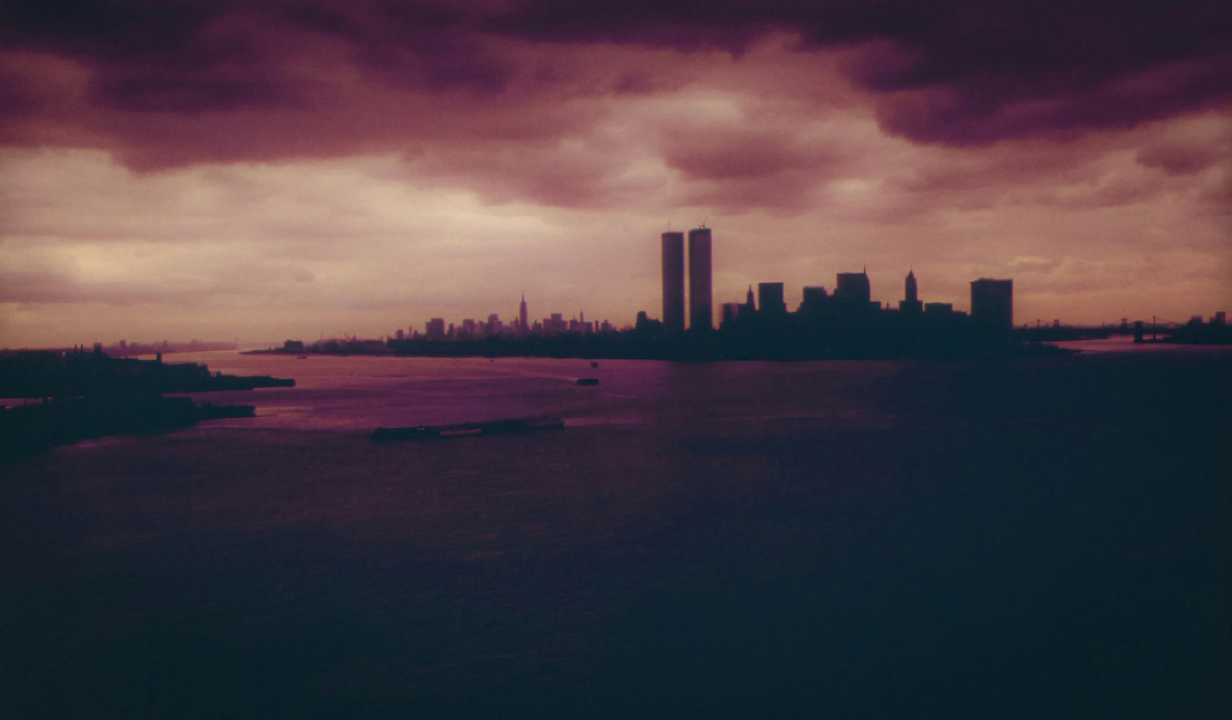 a body of water under a cloudy sky next to tall buildings