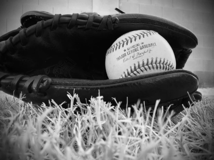 black and white po of a baseball glove with a ball