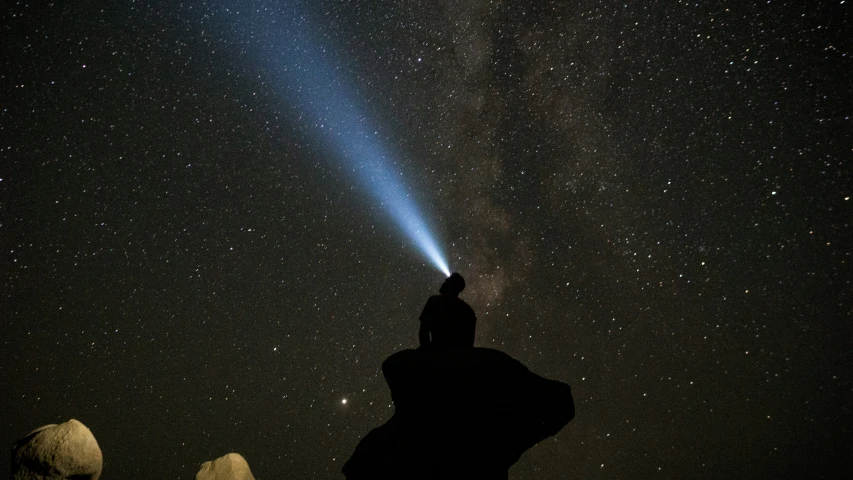 a person looking at the sky through a bright light