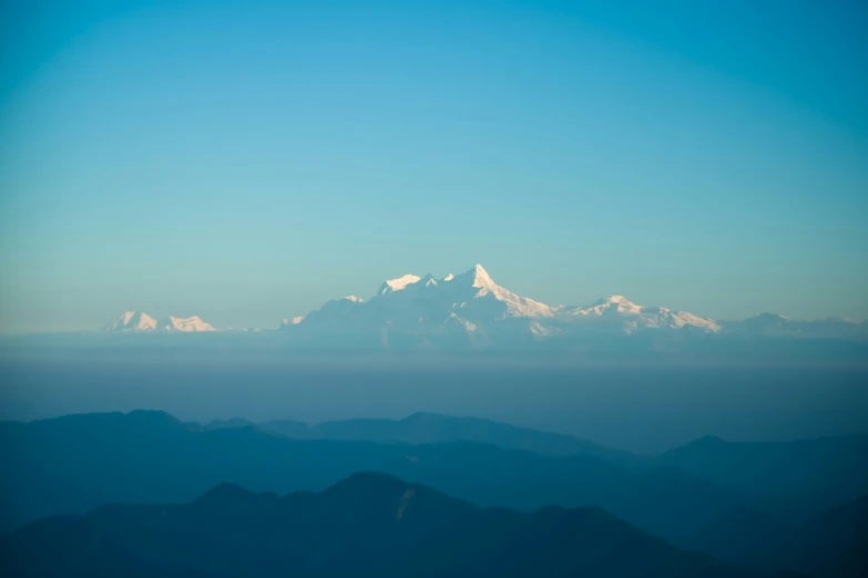 mountains rise beyond the blue cloudless sky