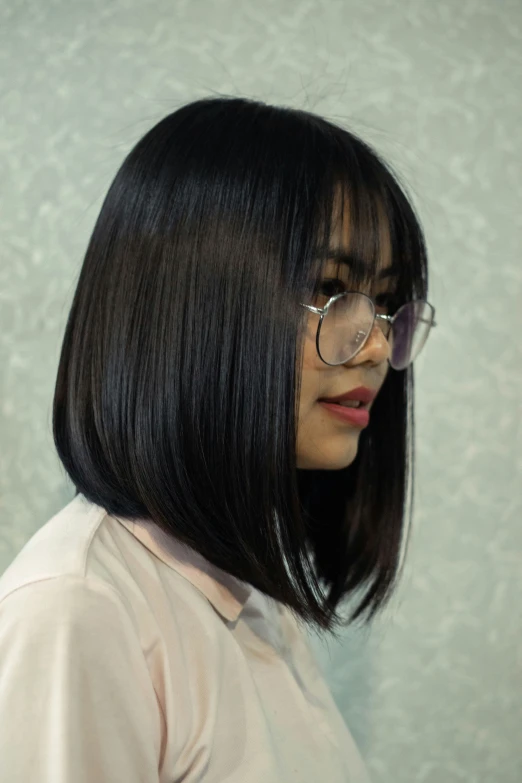 a woman with glasses looking sideways over her shoulder