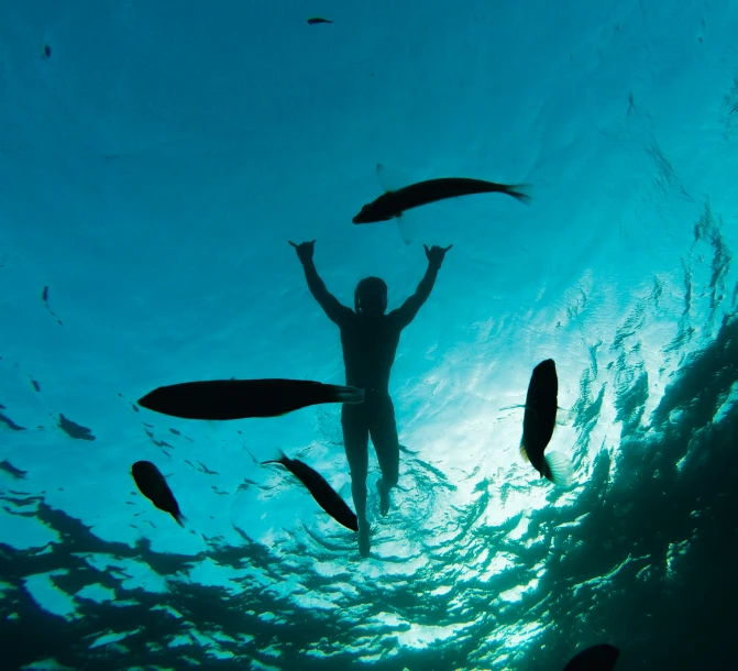 a person holding their arms in the air standing underneath water