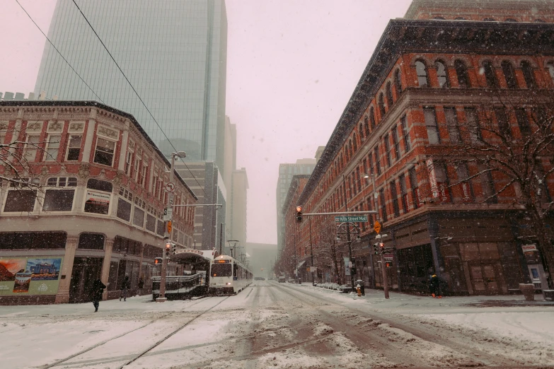 a snow covered street with snow covered buildings and people walking on it