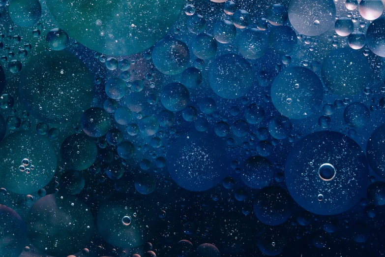 a close up po of blue bubbles and black water