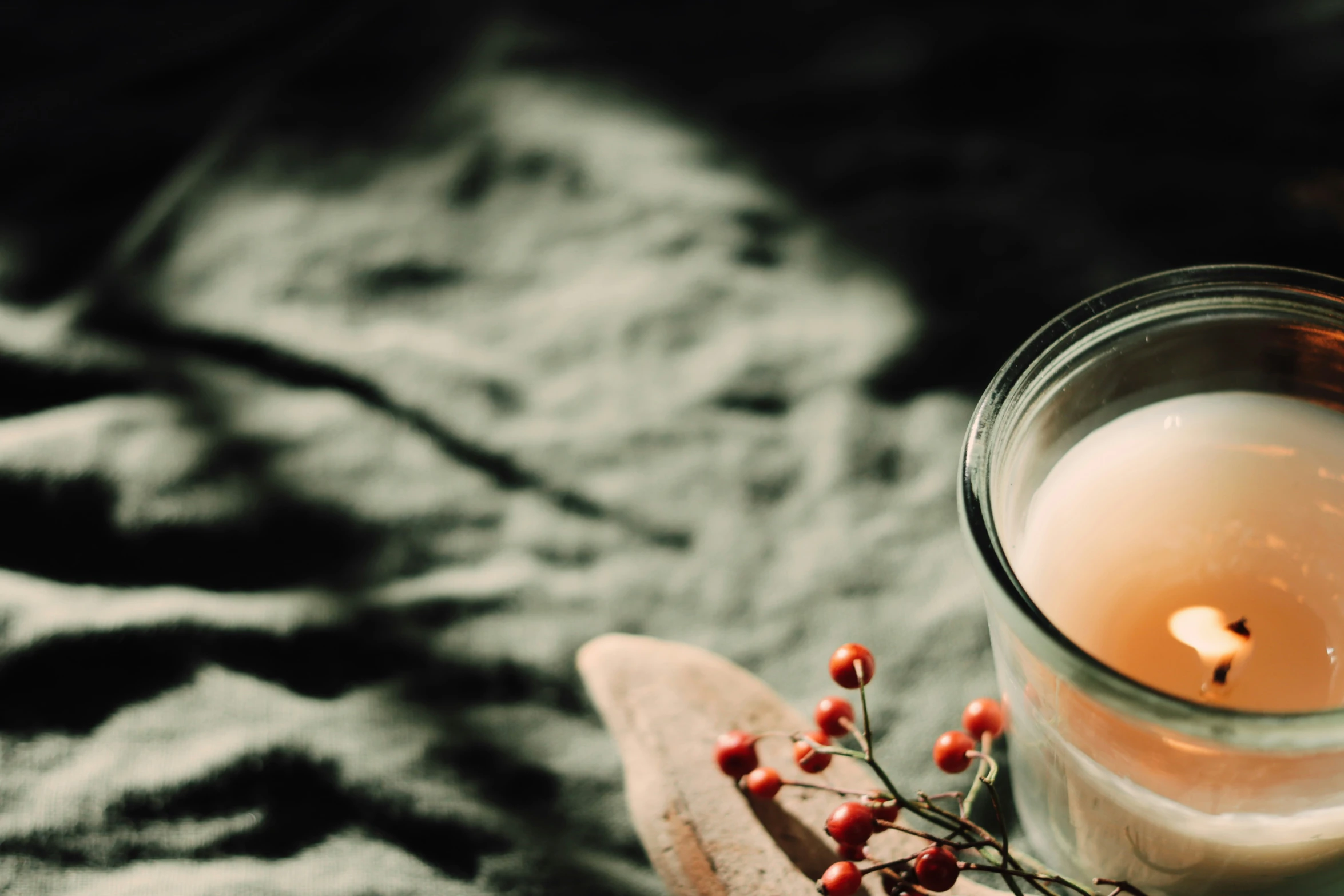 a glass filled with some white liquid next to a wooden spoon