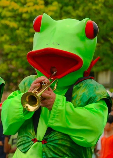 a person wearing a frog costume playing the trumpet