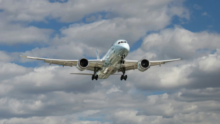 an airplane flies through the sky on a cloudy day