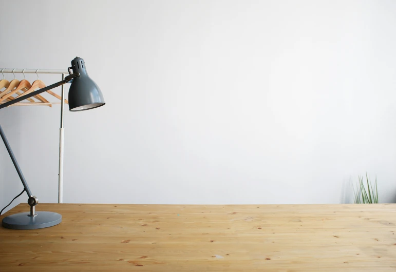 a modern desk lamp in front of an unfinished wall