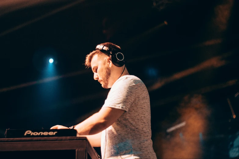 a man in headphones is at the keyboards on stage