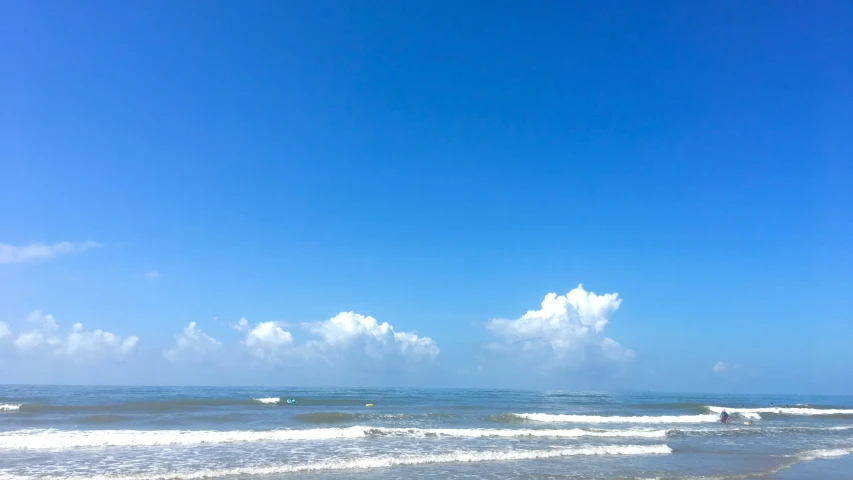 a person holding a surfboard is walking on a beach