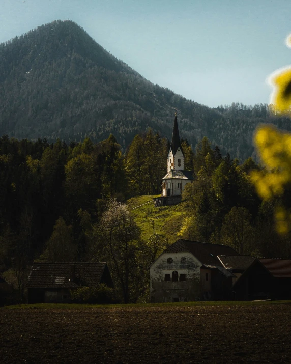 a church perched on a hill covered in trees