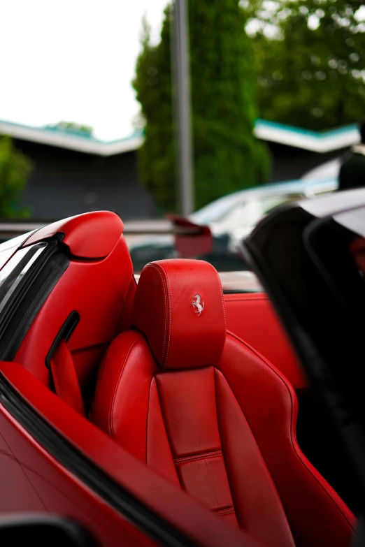 the interior of a red sports car, in front of trees