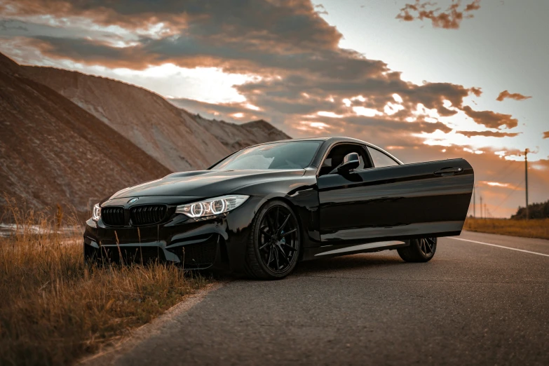 a black bmw parked on the side of the road