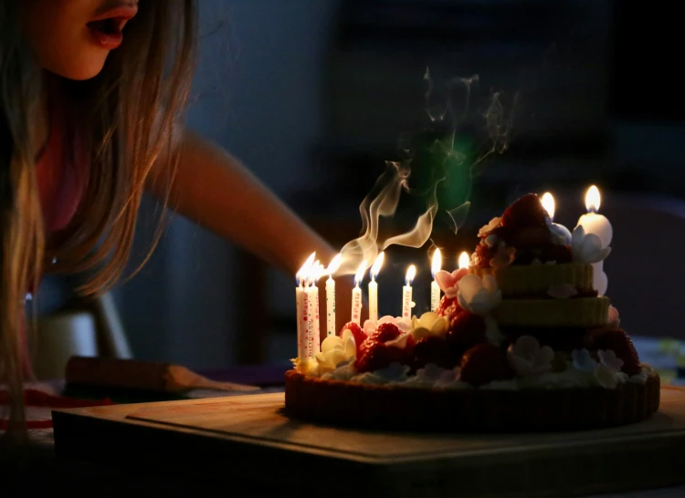 a woman blowing out birthday candles on her cake