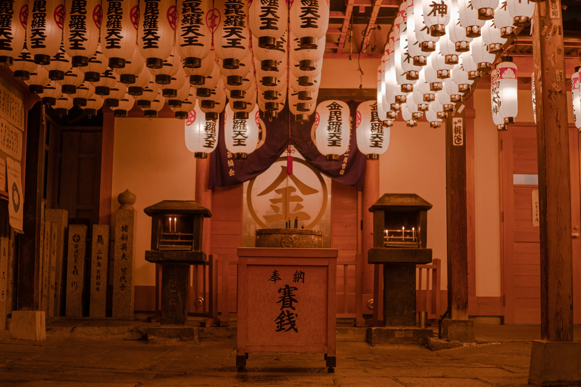 several lanterns hanging in front of a wall with chinese writing