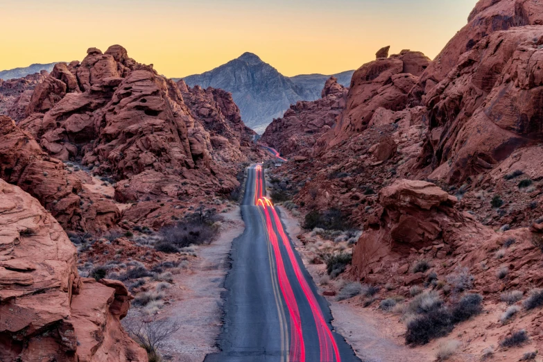 a long, straight road lined with large rocks