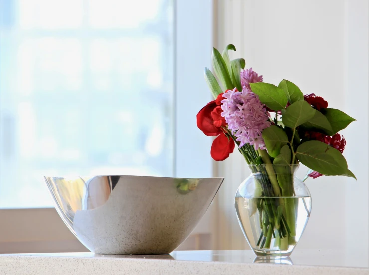 flowers are arranged inside glass vases on a counter