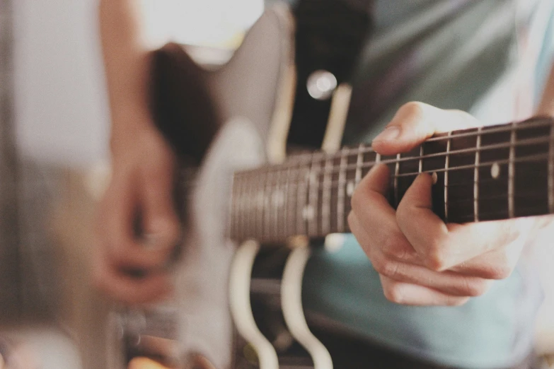 a man playing guitar while wearing blue shirt