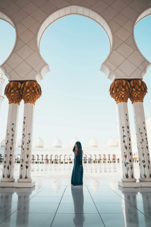 a woman is standing under two archways in the middle of a building