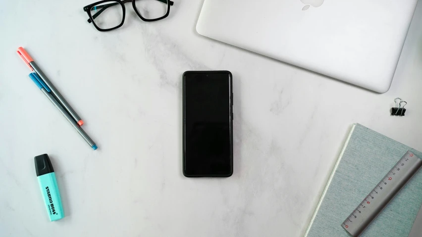 a cell phone a pair of glasses sitting on a table