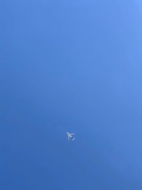 an airplane flying in a blue sky as the sun goes down