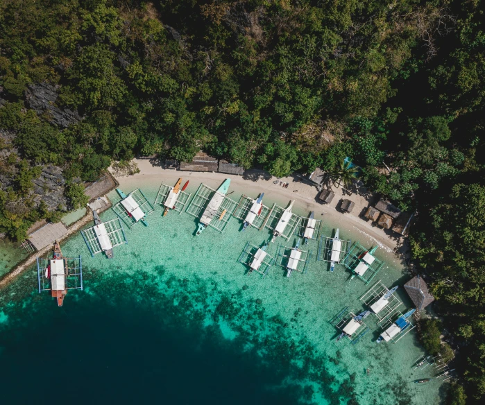 several boats sit on the shore of a lake