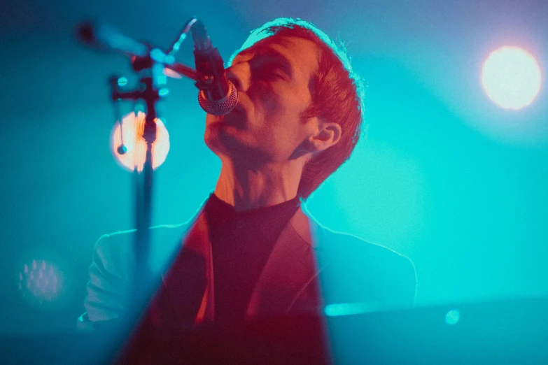 a man on stage singing into a microphone