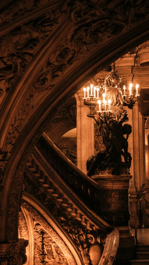 several candles lit up on the chandelier above a staircase