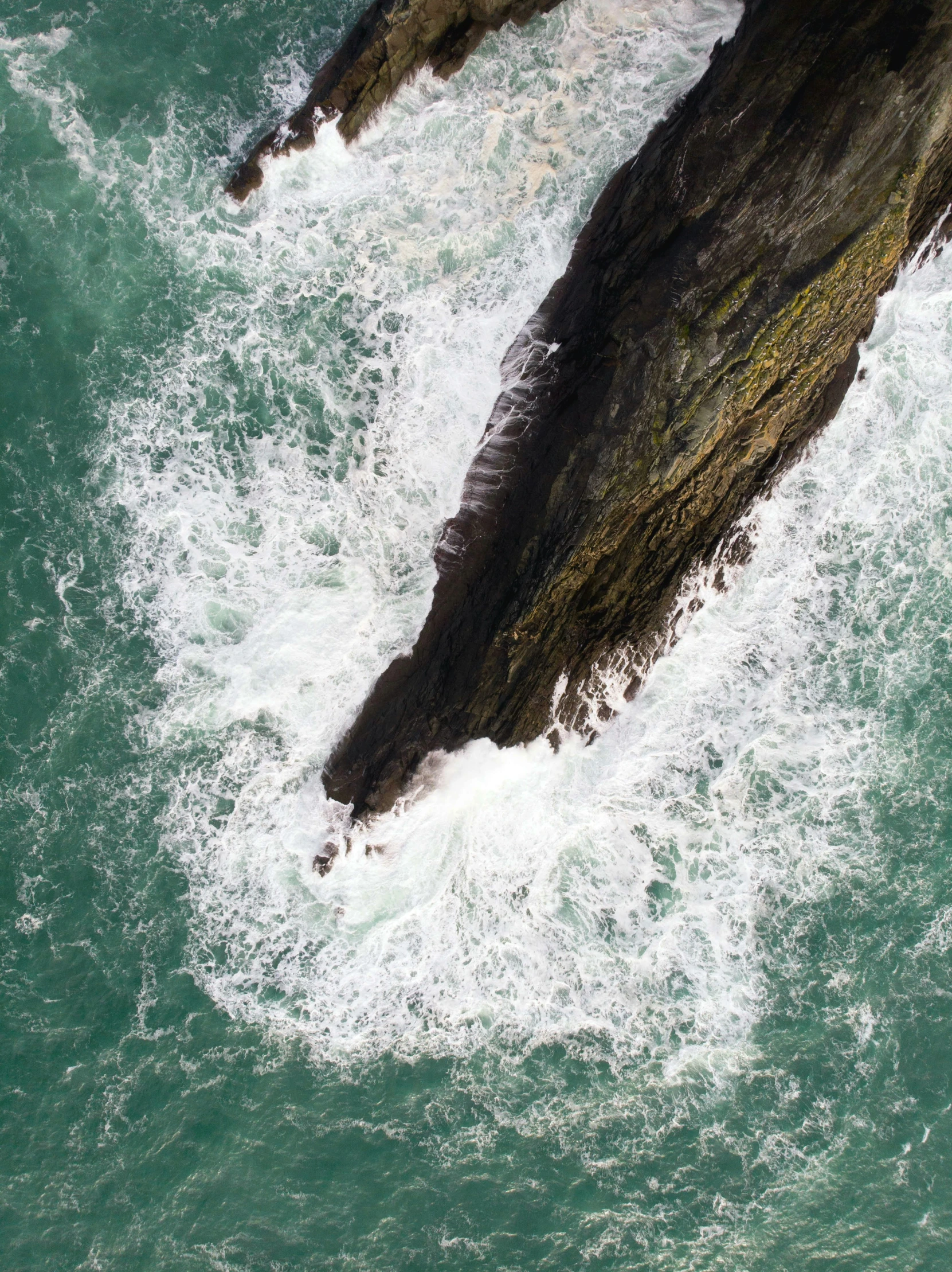 an aerial view of water and rocks from above