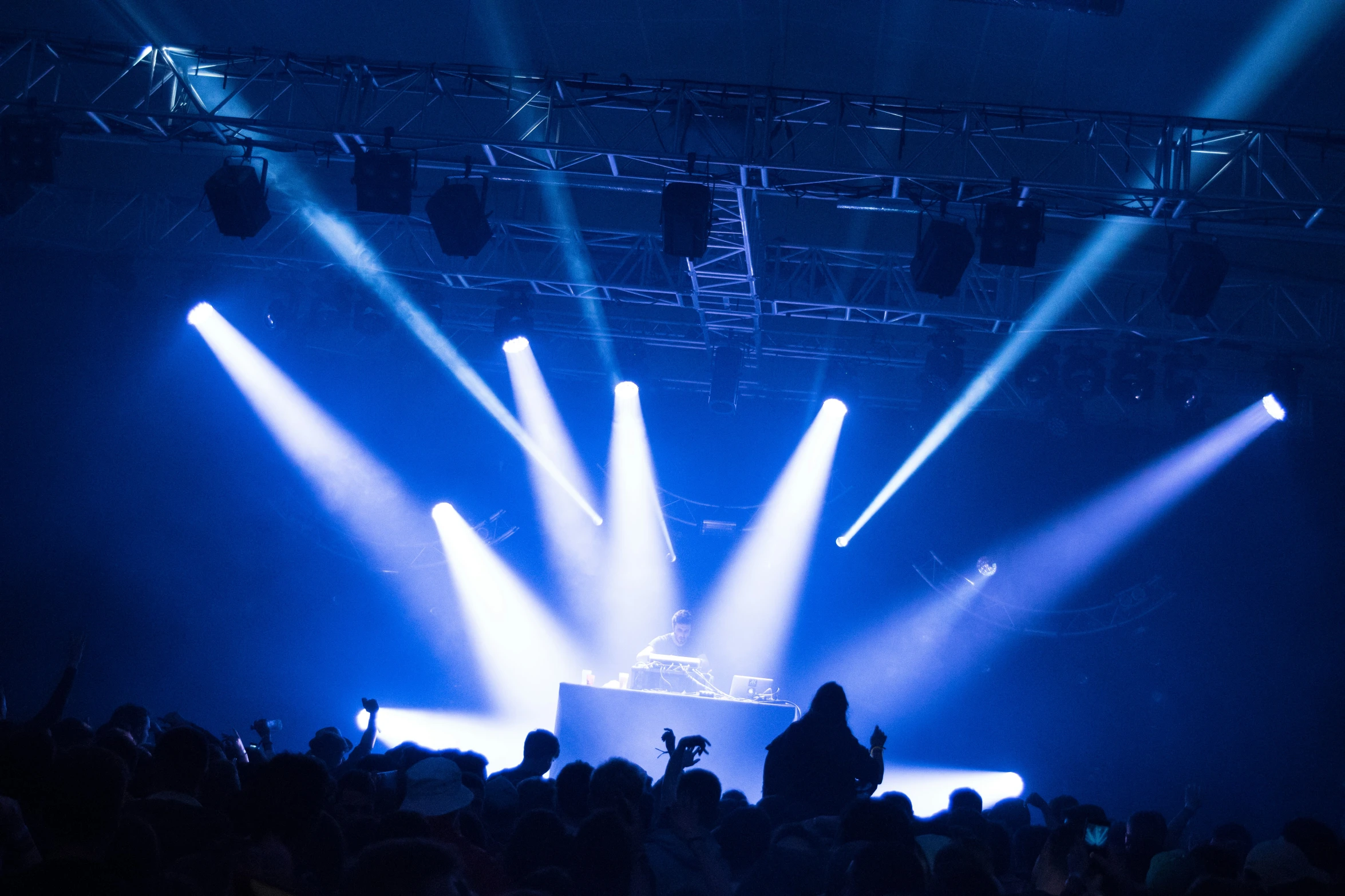 people are standing in front of a stage that has several spotlights