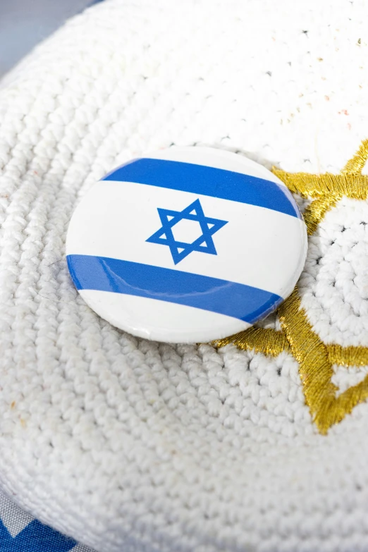 the israeli flag and gold - plated pins are sitting on top of a knit mat