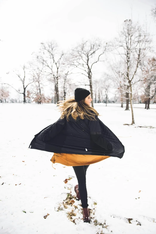 a woman holding a jacket in the snow