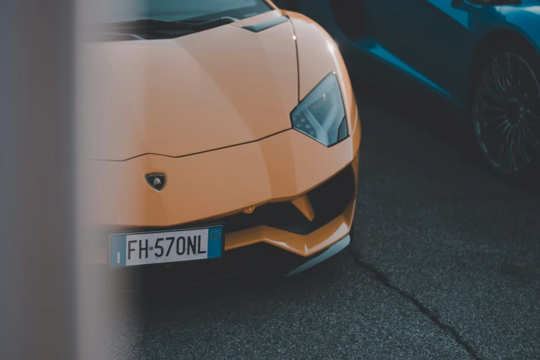 an orange and blue car parked next to each other