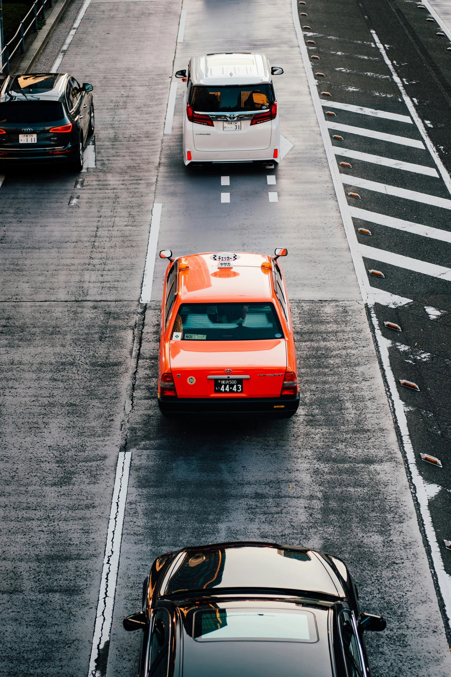 an orange car on the street with other cars