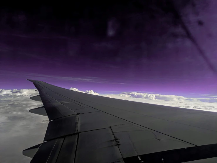 a po taken from inside an airplane looking out the window at a dark sky with clouds