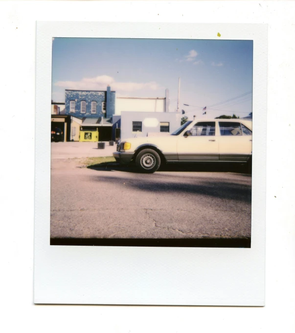 a white car parked on the street with houses in the background