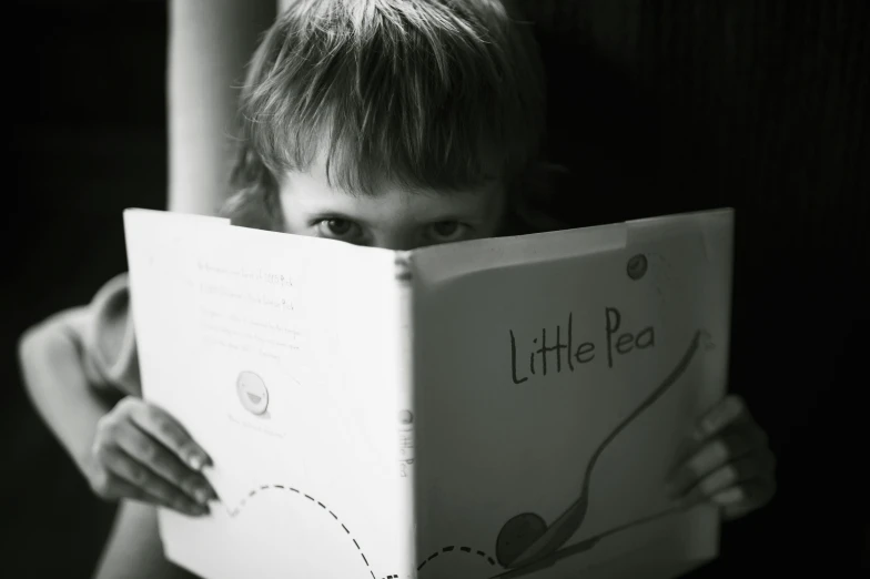 a young child that is looking at a book