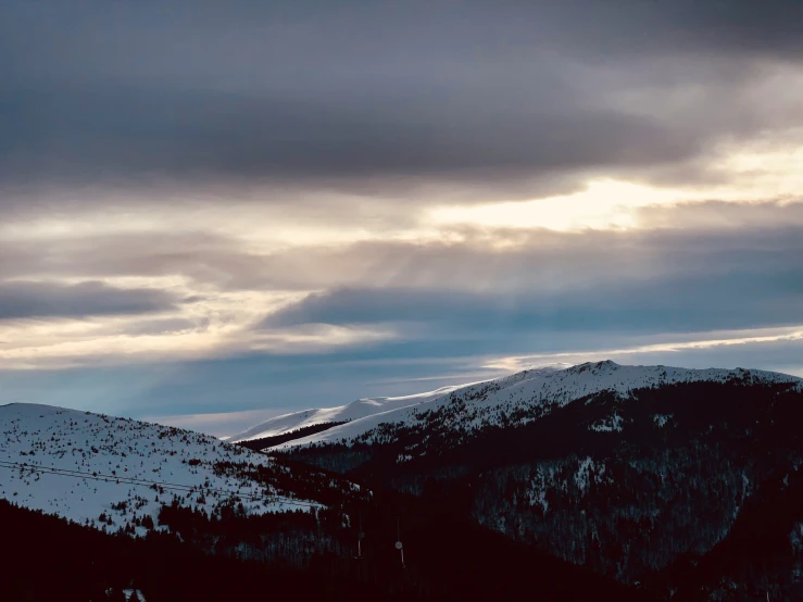 the sky is filled with white clouds as it sits below mountains