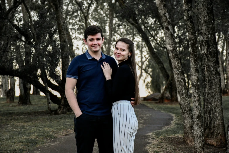 a woman in black standing next to a man