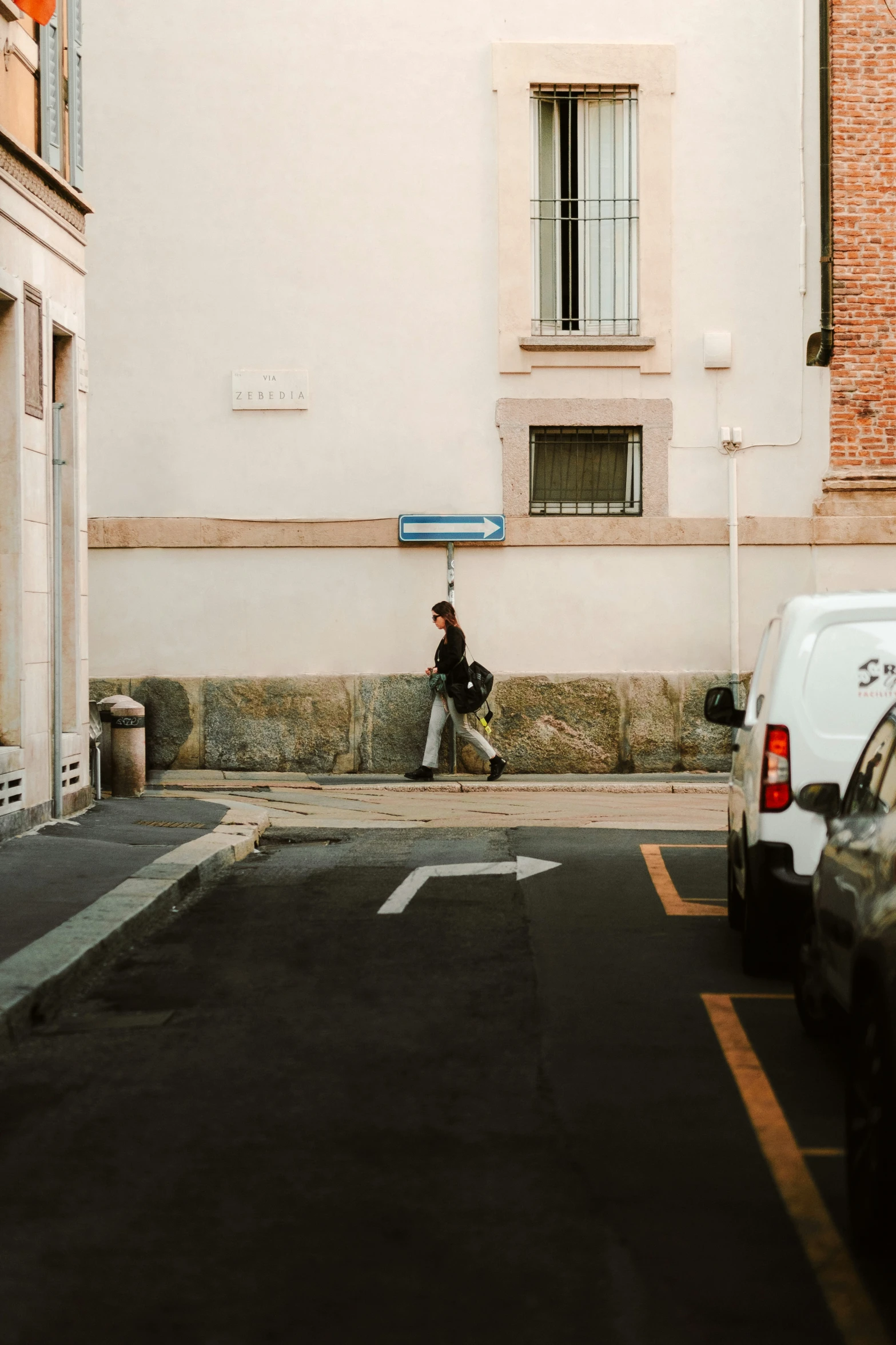 person sitting at a street corner waiting for the bus