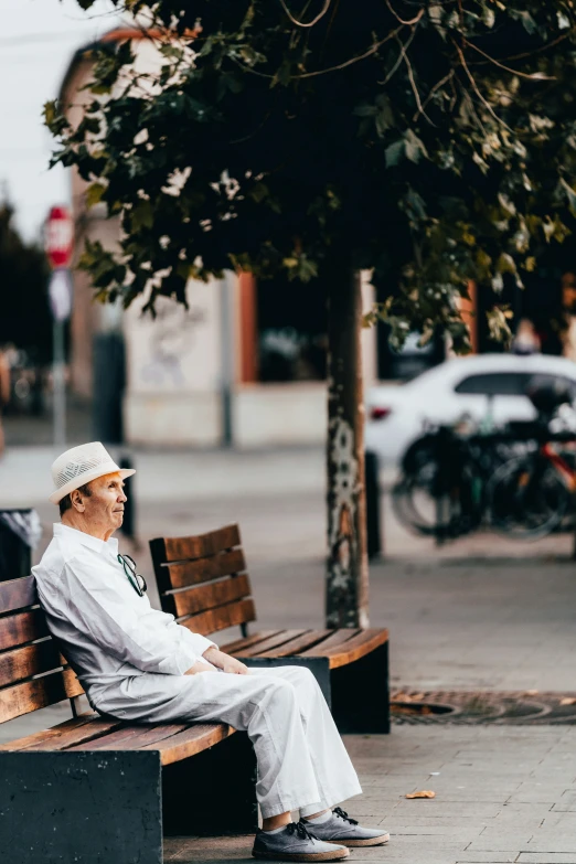 a person in white sitting on a bench