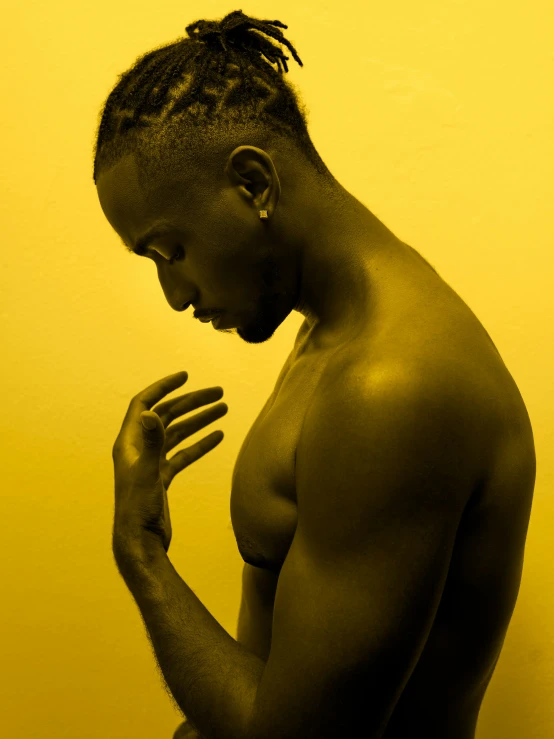 a man with dreadlocks looking down at his hand