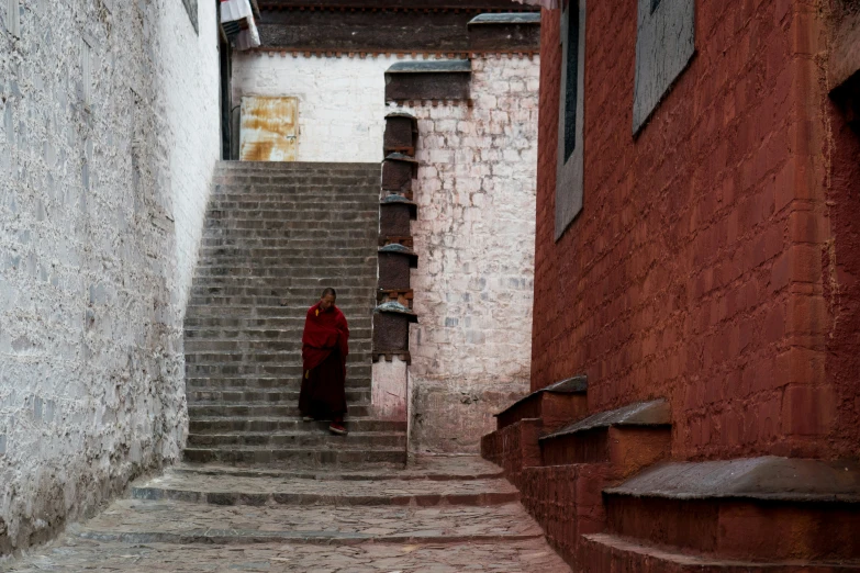 a person standing on some steps wearing a red cloak
